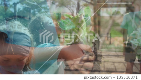 Sniffing girl in short-sleeve blue shirt lifting succulent pot at nursery aisle with metal frames Sniffing girl in short-sleeve blue shirt lifting succulent pot at nursery aisle with metal frames 135316371