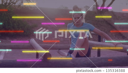 Balancing athlete wearing top and shorts swinging leg over log beam on obstacle course with streaks Balancing athlete wearing top and shorts swinging leg over log beam on obstacle course with streaks 135316388