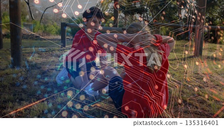 Doing sit-ups child pair holding feet on grass at park, in sportswear with metal bars 135316401