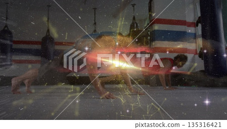 Performing push-ups workout partners at martial arts gym with padded mats and glowing overlay Performing push-ups workout partners at martial arts gym with padded mats and glowing overlay 135316421