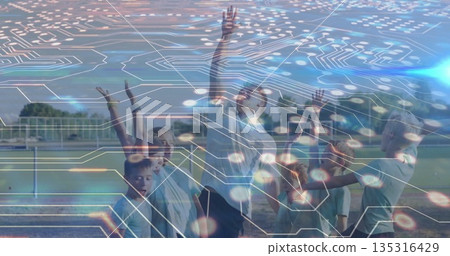 Stretching coach and children in sportswear raising arms on sports field, with soccer goalpost 135316429