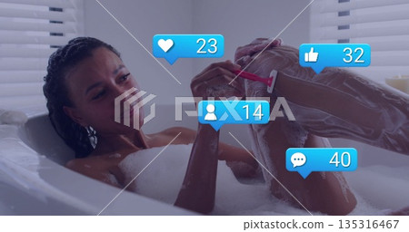 Adult woman shaving leg in foam-filled tub in home bathroom with blinds, red razor, reaction icons 135316467