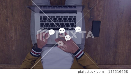 Typing man wearing mustard jacket using laptop at home office, with smart devices and chat icons Typing man wearing mustard jacket using laptop at home office, with smart devices and chat icons 135316468