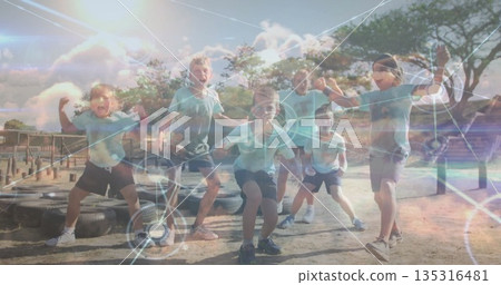 Six kids striking athletic stances in obstacle course area, with worn tires and digital overlay 135316481