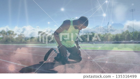 Kneeling teenage athlete adjusting prosthetic blade at start line, with light overlay 135316499