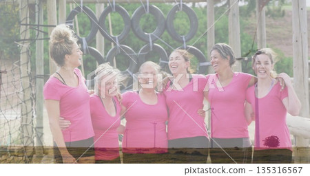 Standing six women wearing pink shirts and black leggings in obstacle course, with tire rings, net 135316567