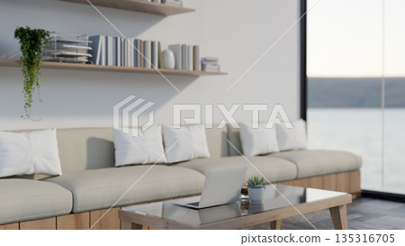 Laptop and coffee cup on glass top wooden table aside fabric sofa set in living room or cafe lounge. 135316705