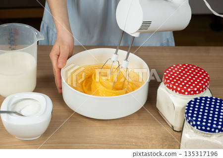 Close-up of the Baking Process. Preparing Dough with a Mixer on a Kitchen Countertop. 135317196