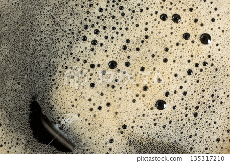 Macro texture of golden coffee foam with many small bubbles. Macro texture of golden coffee foam with many small bubbles. 135317210