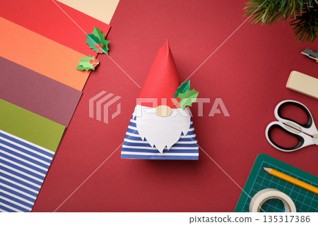Finished handmade crafts gnome made of colored paper. DIY holiday decoration idea. 135317386