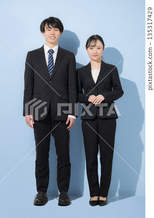 一位年輕的商人和一位看起來像大學生的女士，背景是淺藍色。這是一張企業招募圖片，傳達了對應屆畢業生招募和就業的信任。 135317429