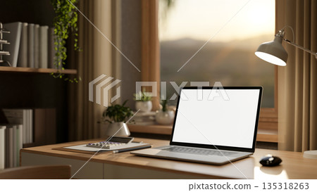 Blank screen laptop with books and calculator on wooden table under window in a sunlit living room. Blank screen laptop with books and calculator on wooden table under window in a sunlit living room. 135318263