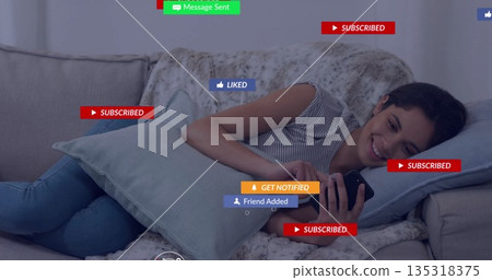 Reclining woman in striped top hugging cushion, scrolling smartphone at home on sofa, digital icons Reclining woman in striped top hugging cushion, scrolling smartphone at home on sofa, digital icons 135318375