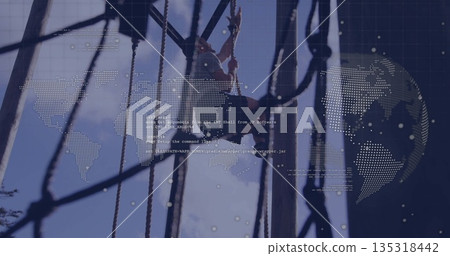 Navigating man wearing helmet and harness crossing ropes course at park with poles, digital overlay 135318442
