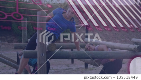 Climbing woman in blue shirt and leggings over beam on dirt obstacle course, with bolted posts Climbing woman in blue shirt and leggings over beam on dirt obstacle course, with bolted posts 135318449