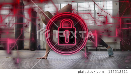 Holding side plank woman wearing black sportswear at gym, with neon padlock icon and punching bags Holding side plank woman wearing black sportswear at gym, with neon padlock icon and punching bags 135318511