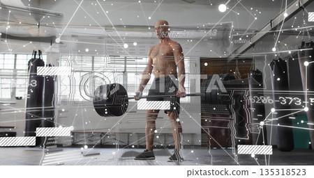 Deadlifting shirtless man gripping loaded barbell in gym, with punching bags and digital overlay Deadlifting shirtless man gripping loaded barbell in gym, with punching bags and digital overlay 135318523