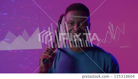 Holding tennis racket on shoulder man in blue sports shirt showing bar-chart line-graph in studio Holding tennis racket on shoulder man in blue sports shirt showing bar-chart line-graph in studio 135318604
