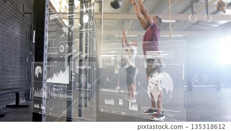 Man in purple tee slamming overhead medicine balls in gym with HUD overlays, rings, copy space Man in purple tee slamming overhead medicine balls in gym with HUD overlays, rings, copy space 135318612