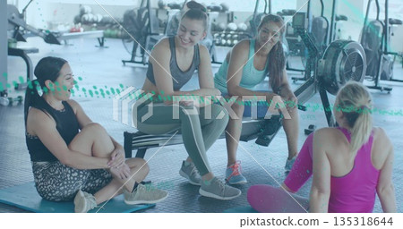 Pausing workout four women sitting and kneeling inside gym, with foam mats and dumbbells Pausing workout four women sitting and kneeling inside gym, with foam mats and dumbbells 135318644