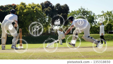 Bowler delivering ball and batsman lunging with bat in grass pitch, with digital icons, copy space 135318650