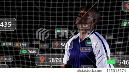 Standing player wearing blue white jersey in front of goal net, floating digital icons, copy space Standing player wearing blue white jersey in front of goal net, floating digital icons, copy space 135318674