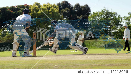 Diving batsman sliding into crease on cricket pitch, with ball stumps and digital world map overlay 135318696