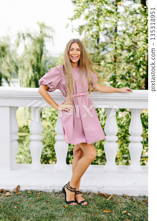 Smiling Woman In Pink Dress Outdoors Smiling Woman In Pink Dress Outdoors 135318951