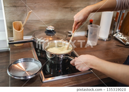Stirring creamy rice in a modern kitchen on a cozy afternoon 135319028