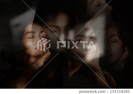 A woman with black hair wakes up in the morning in a white blanket and catches the rays of the sun. The portrait is creative, with brown eyes. High quality photo 135319295