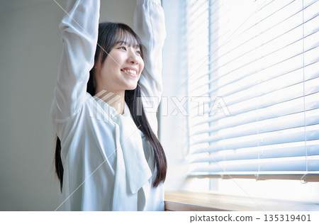 一位二十多歲女性的美麗肖像,她伸展著身體 一位二十多歲女性的美麗肖像,她伸展著身體 135319401