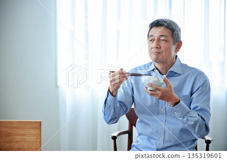 Senior man eating rice 135319601