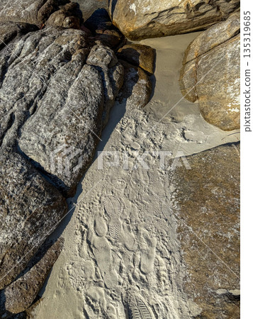 Footprints In Sand Between Coastal Rocks 135319685