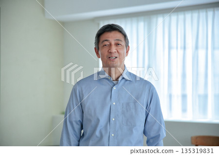 一位六十多歲的微笑的男子站著,看著鏡頭。 一位六十多歲的微笑的男子站著,看著鏡頭。 135319831