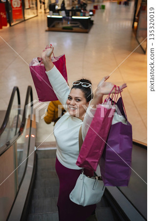 Joyful shopper celebrates a successful day at the mall 135320019