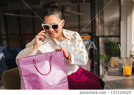 Joyful shopping experience in a trendy cafe on a sunny afternoon 135320020