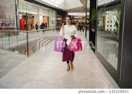 Stylish shopper enjoys a fun day at the mall with vibrant bags 135320031