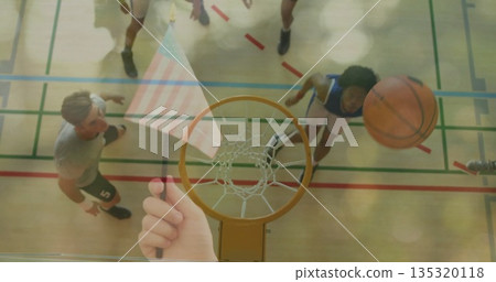 Passing basketball flying through hoop above gym court, players jumping, tablet streaming action 135320118