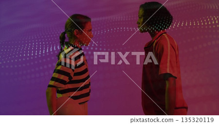 Posing two women wearing sportswear facing each other in studio with ball and light projection Posing two women wearing sportswear facing each other in studio with ball and light projection 135320119