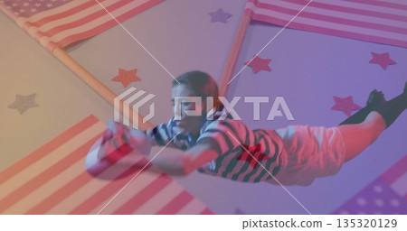 Diving performer wearing striped outfit reaching in studio, with American flag panels and sphere Diving performer wearing striped outfit reaching in studio, with American flag panels and sphere 135320129