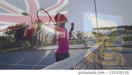 Tennis player pumping fist near net at sunset at park court, with racket, UK flag overlay Tennis player pumping fist near net at sunset at park court, with racket, UK flag overlay 135320130