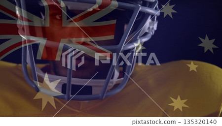 Displaying football player wearing helmet and yellow jersey in studio, Australian flag overlay Displaying football player wearing helmet and yellow jersey in studio, Australian flag overlay 135320140