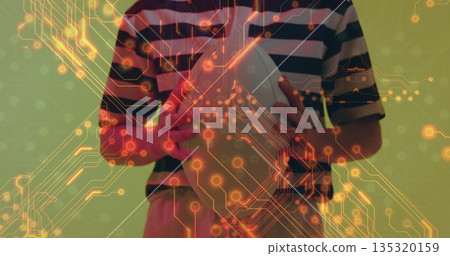 Showing striped shirt woman holding white oval sports ball against green wall, with circuit overlay 135320159