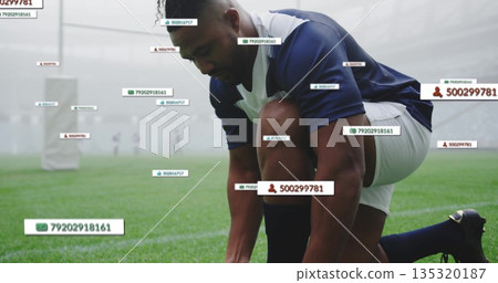 Kneeling athlete wearing cleats tying laces on misty field, with goalposts and tracking tags Kneeling athlete wearing cleats tying laces on misty field, with goalposts and tracking tags 135320187