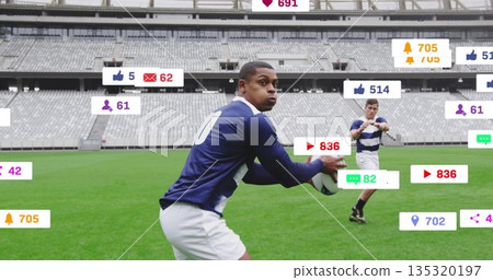 Rugby player wearing blue-and-white uniform holding ball on stadium field, digital overlay icons 135320197