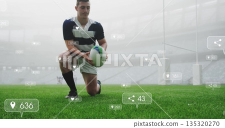 Kneeling rugby player in striped jersey, shorts placing ball on stadium turf, with floating icons Kneeling rugby player in striped jersey, shorts placing ball on stadium turf, with floating icons 135320270