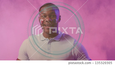 Standing male in polo shirt with paint stripes facing viewer in studio, with digital overlay rings 135320305