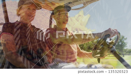 Riding senior couple wearing golf attire cruising fairway in golf cart, with steering wheel view 135320323