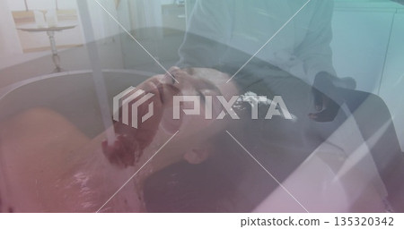 Reclining woman feeling water flowing from faucet over brow in spa room, with bathtub, chrome taps 135320342