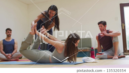 Guiding instructor assisting participant performing bow pose in bright studio, with yoga mats Guiding instructor assisting participant performing bow pose in bright studio, with yoga mats 135320354